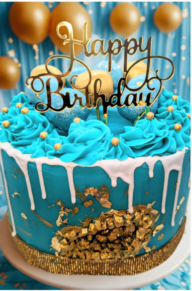 Blue birthday cake with gold decorations and 'Happy Birthday' topper